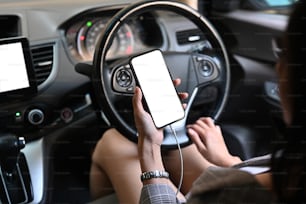 Young attractive woman using smart phone texting or read message while driving the car.