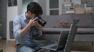 젊은 남자 사진 작가는 촬영 전에 카메라 설정을 확인하고 조정합니다.