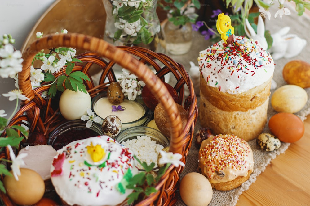 Comida tradicional de Pascua para bendecir, pan de Pascua casero, elegantes huevos de Pascua y flores de primavera en flor en servilleta de lino sobre mesa rústica. ¡Felices Pascuas! Desayuno festivo