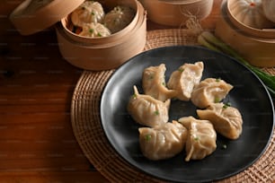 Cropped shot of kitchen table with a plate of dumplings and bamboo steamer