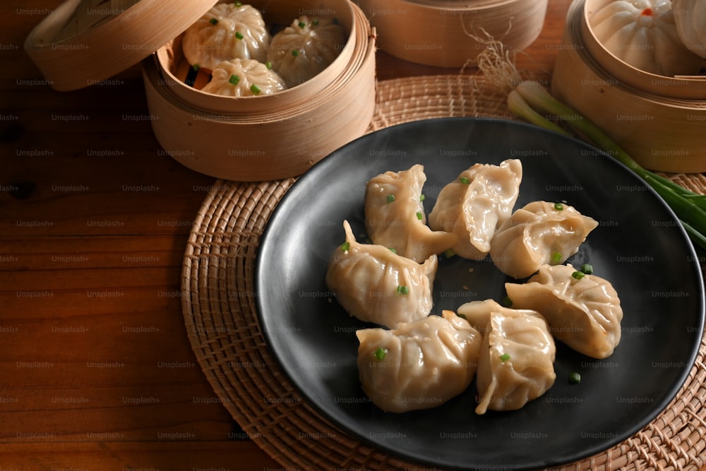 Cropped shot of kitchen table with a plate of dumplings and bamboo steamer