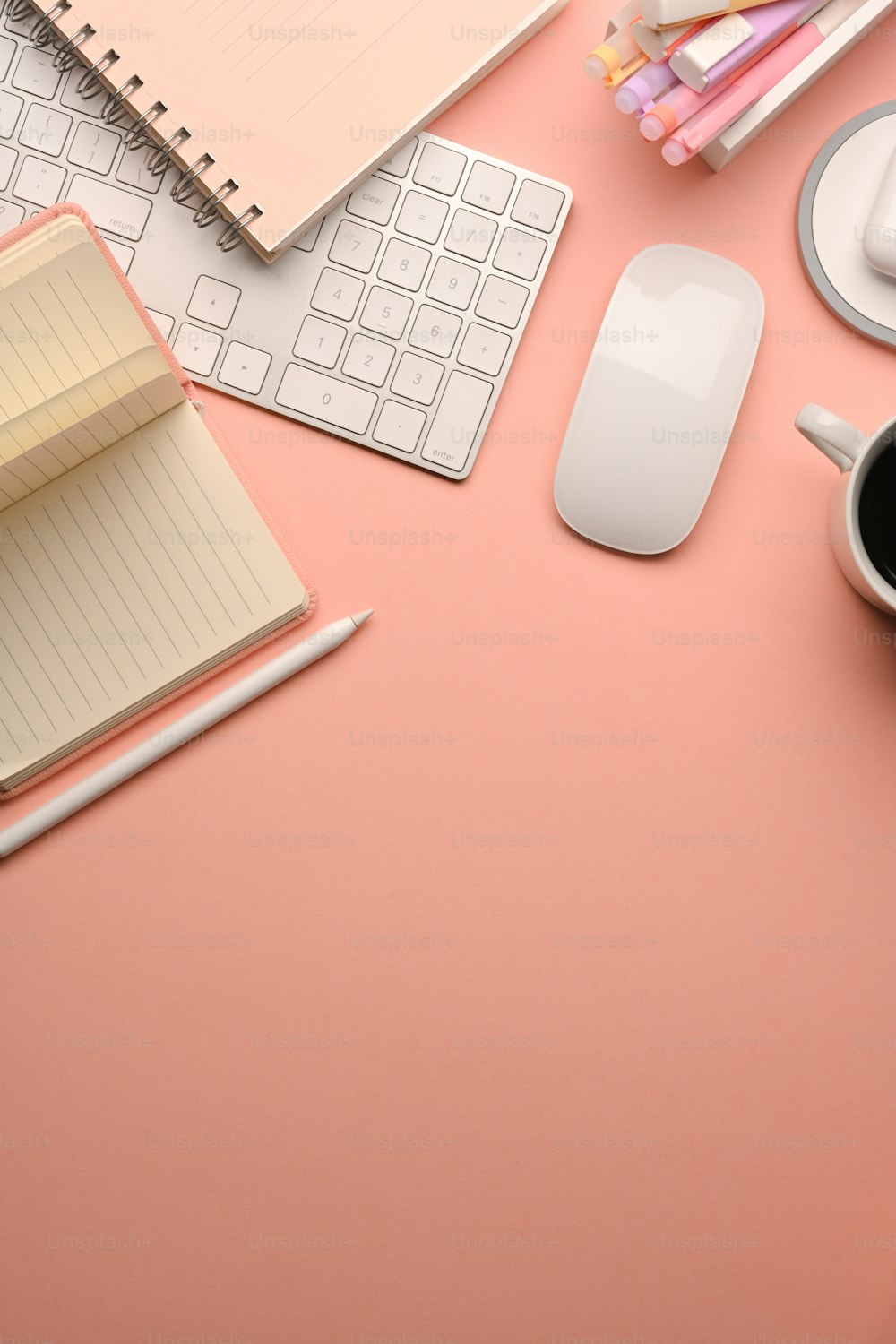 Foto recortada de la mesa de estudio creativa rosa con el teclado de la computadora, el ratón, la papelería y el espacio de copia