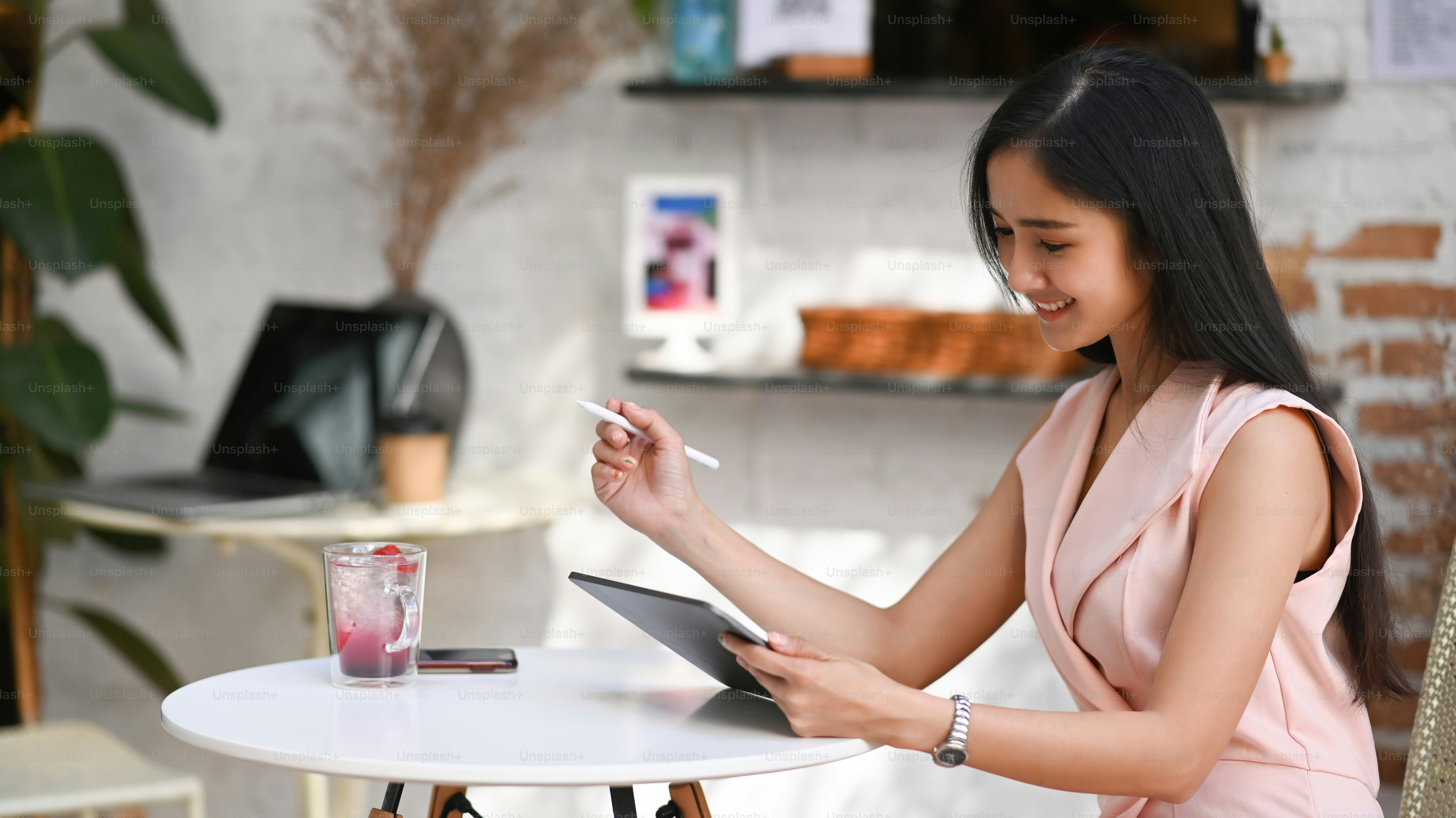 Young stylish woman sitting in cafe and using digital tablet.