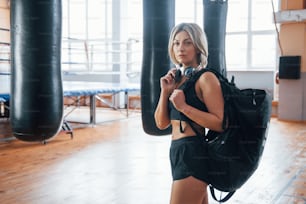 健康的なライフスタイルの構想。トレーニングジムで黒いバッグとヘッドフォンをした成人女性。