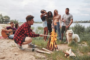 Continua a bruciare. Un gruppo di persone fa un picnic sulla spiaggia. Gli amici si divertono nel fine settimana.