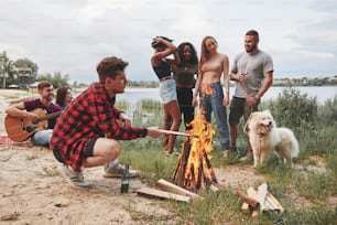 Sigue ardiendo. Un grupo de personas hace un picnic en la playa. Los amigos se divierten el fin de semana.