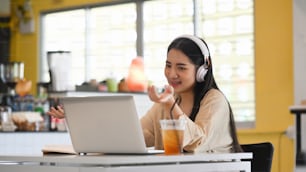 コーヒーショップでコンピューターのラップトップでビジネスパートナーと若い女性のビデオ通話。