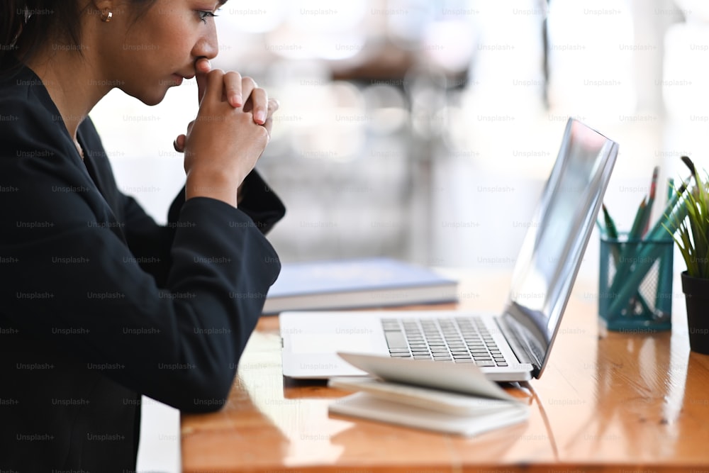 Side view of serious businesswoman concentrate working laptop in office.