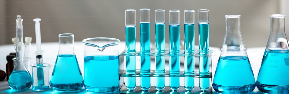 Cristalería de laboratorio de química, concepto de investigación y desarrollo de laboratorio de ciencias, matraz, vaso de precipitados y tubos de ensayo con prueba de muestra de agua líquida azul, equipo de tubos de ensayo científicos