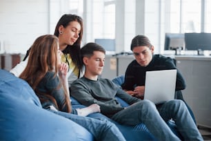 Difficile de trouver l’information dont nous avons besoin. Groupe de jeunes en vêtements décontractés travaillant dans le bureau moderne.