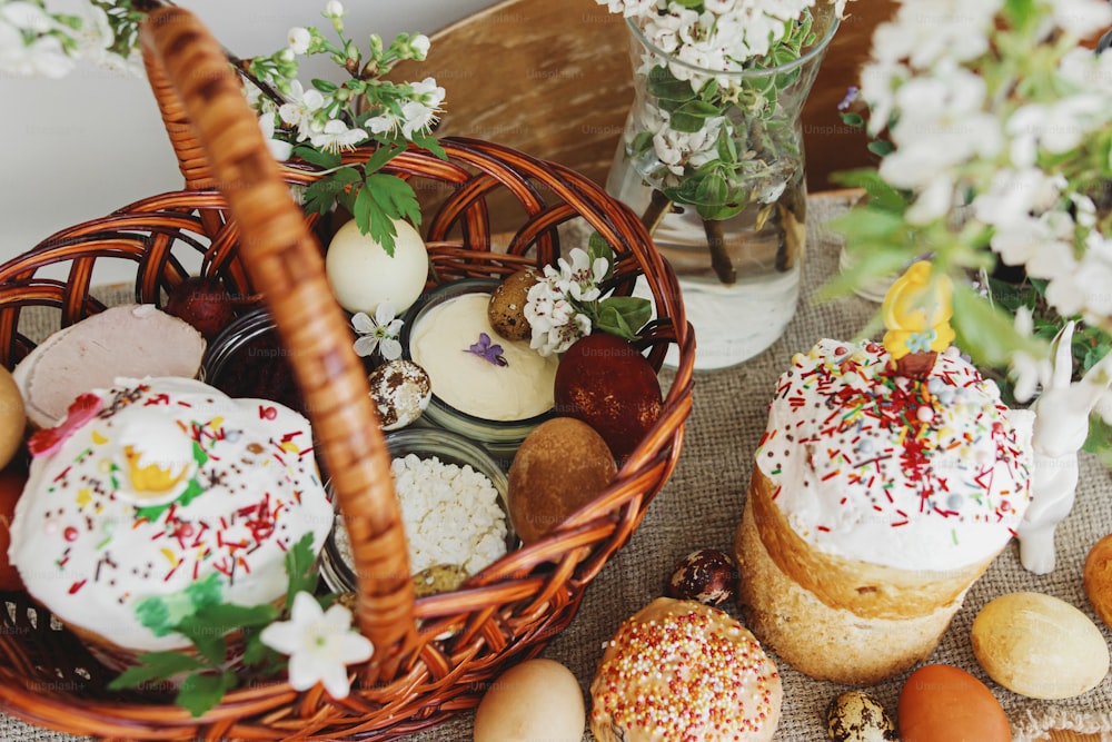 Comida tradicional de Páscoa para bênção, pão de Páscoa caseiro, ovos de páscoa elegantes e flores de primavera florescentes em guardanapo de linho na mesa rústica. Feliz Páscoa! Café da manhã festivo