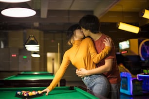 Le couple s’embrasse dans la salle de billard. Couple dans la salle de jeux.