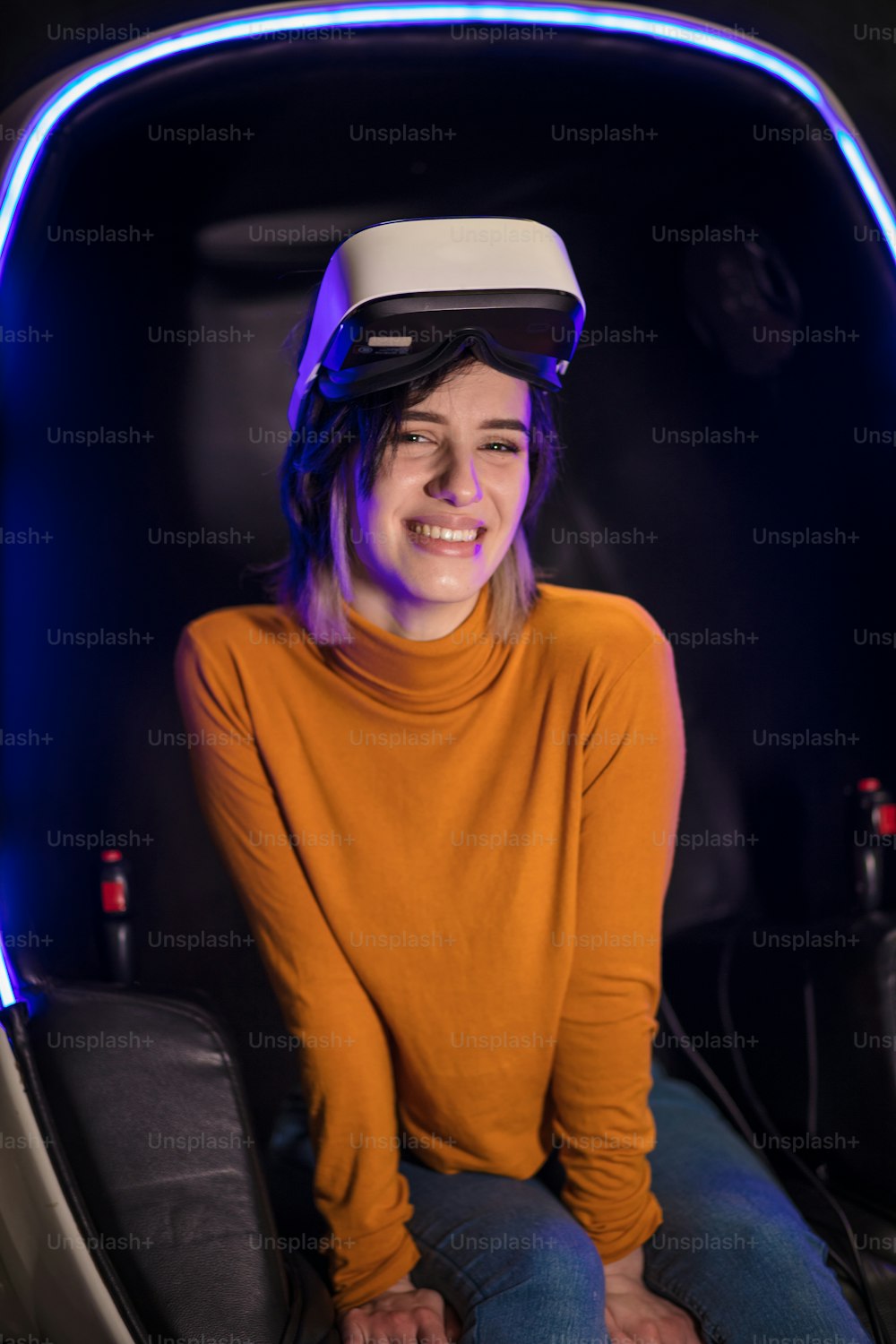 Mujer joven en sala de juegos con casco de realidad virtual. Retrato. Mirando a la cámara.