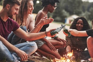No hay fiestas sin alcohol para ellos. Un grupo de personas hace un picnic en la playa. Los amigos se divierten el fin de semana.