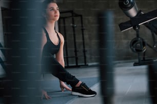 Photo through the metal objects. Photo of gorgeous blonde woman in the gym at her weekend time.