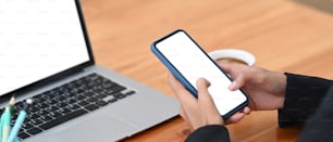 Horizontal photo of businesswoman holding smart phone with white screen.