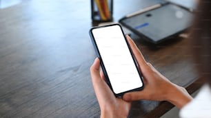 Close up view of young woman  relaxing at her workplace and using mobile phone.