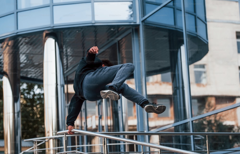 Young man doing parkour in the city at daytime. Conception of extreme sports.