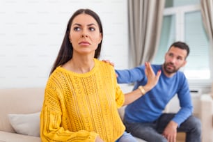 Stressed young man saying sorry after quarrel to frustrated wife. Depressed offended woman ignoring apologizing husband . Family relations problems, divorce, break up concept.