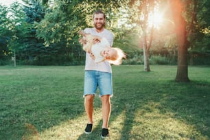 Fathers Day. Proud father spinning toddler baby boy outdoor. Parent playing with child son in park. Authentic lifestyle funny moment. Happy dad family life concept. Childhood and fatherhood.