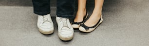 Closeup of man and woman legs in outdoor shoes together. Couple dating sitting together. Love and romance. Romantic dating. Details and body parts. Web banner header.