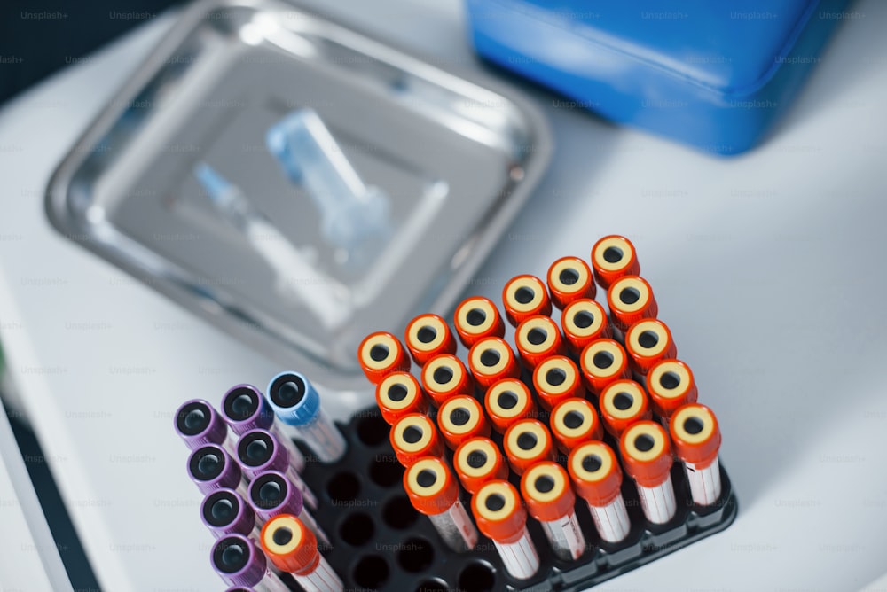 Top view of vials with medical experimental liquid that stands on white surface.