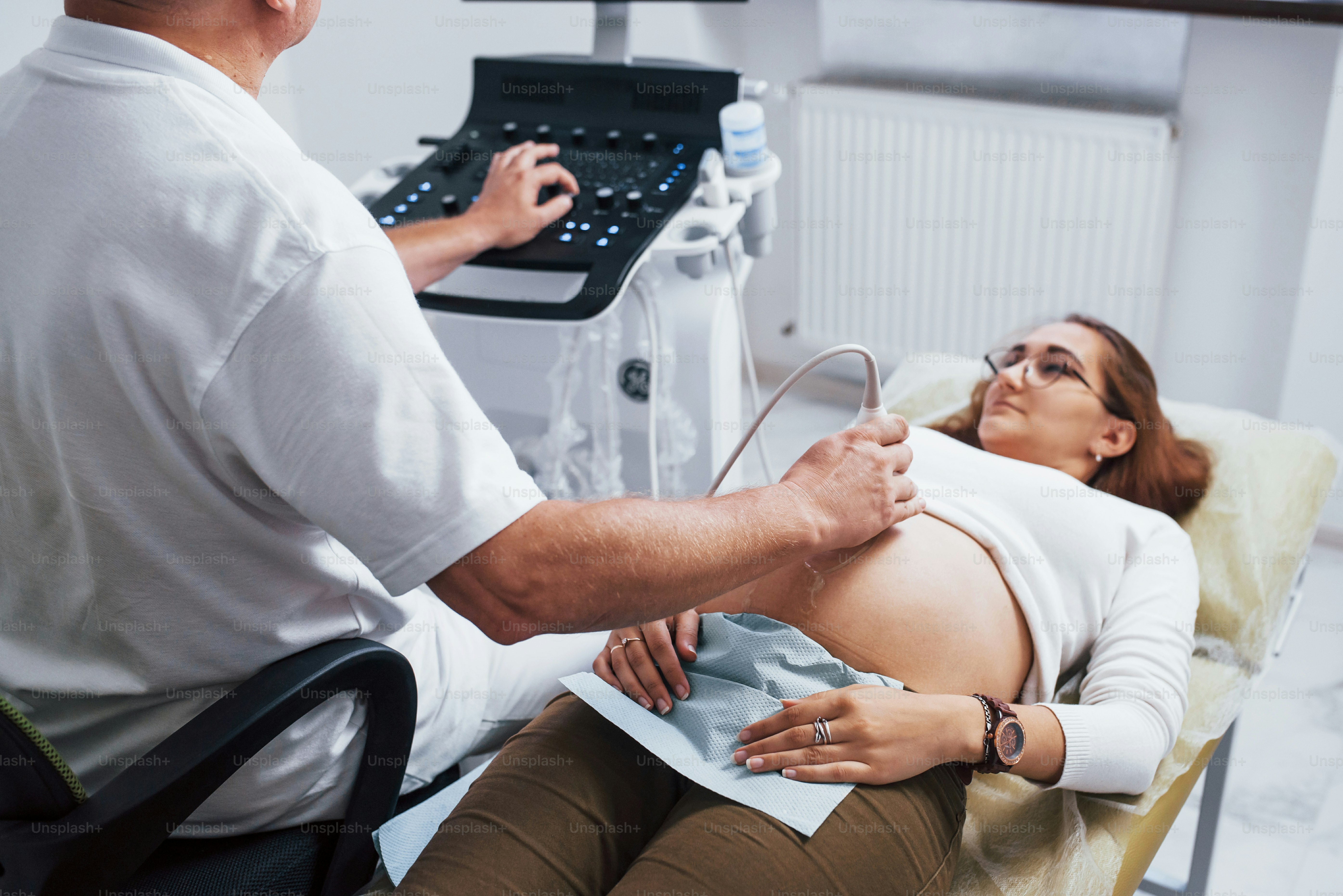 Male doctor does ultrasound for a pregnant woman in the hospital.