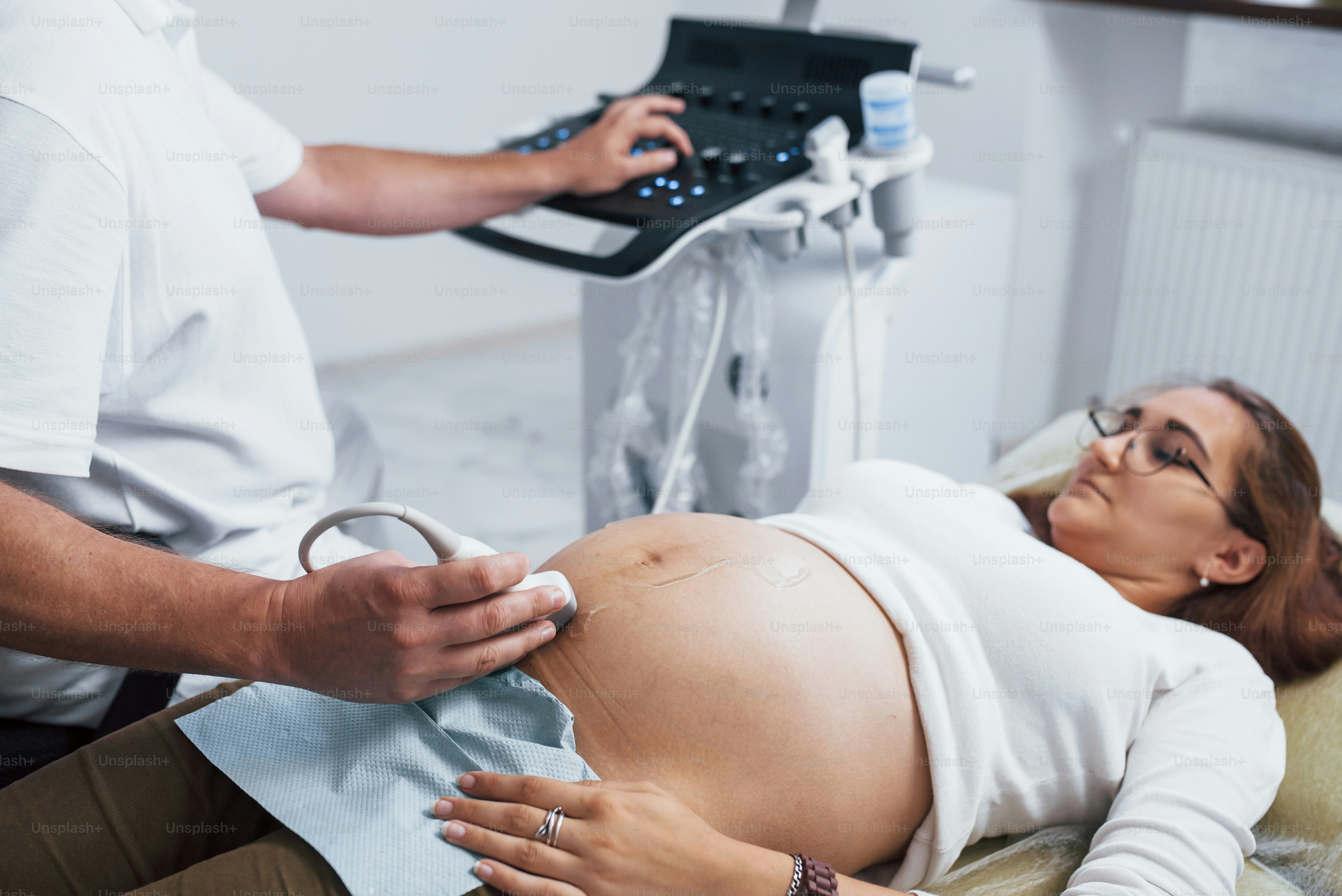 Male doctor does ultrasound for a pregnant woman in the hospital.