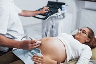Male doctor does ultrasound for a pregnant woman in the hospital.