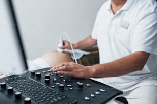 남성 의사는 병원에서 임산부를 위해 초음파 검사를합니다.