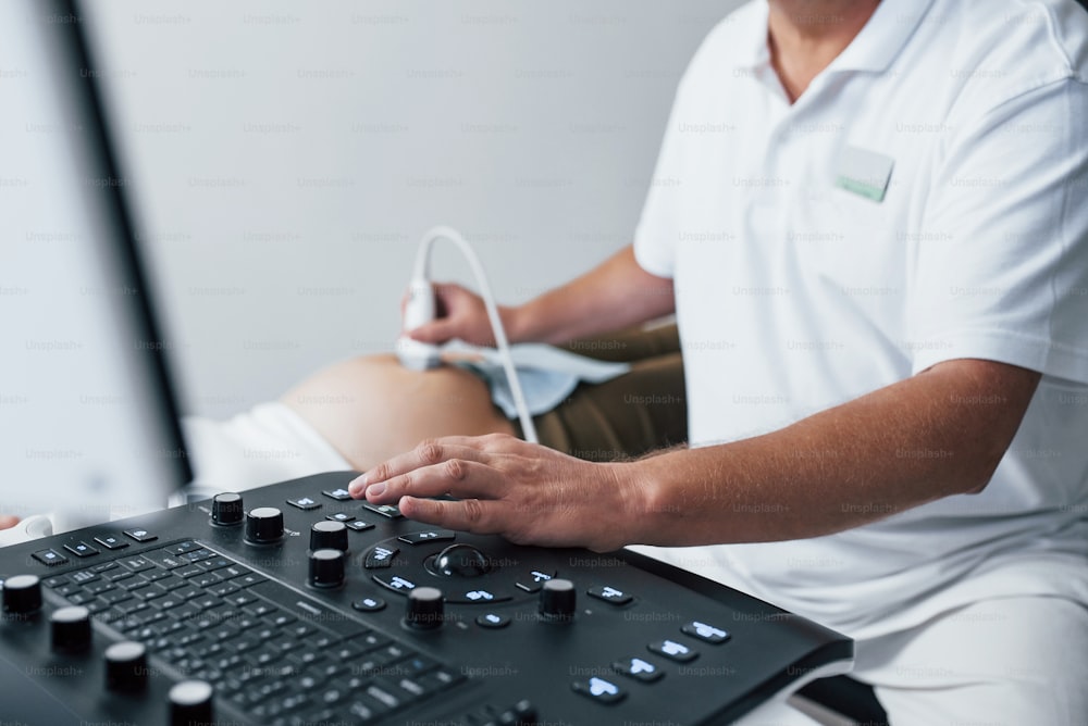 Male doctor does ultrasound for a pregnant woman in the hospital.