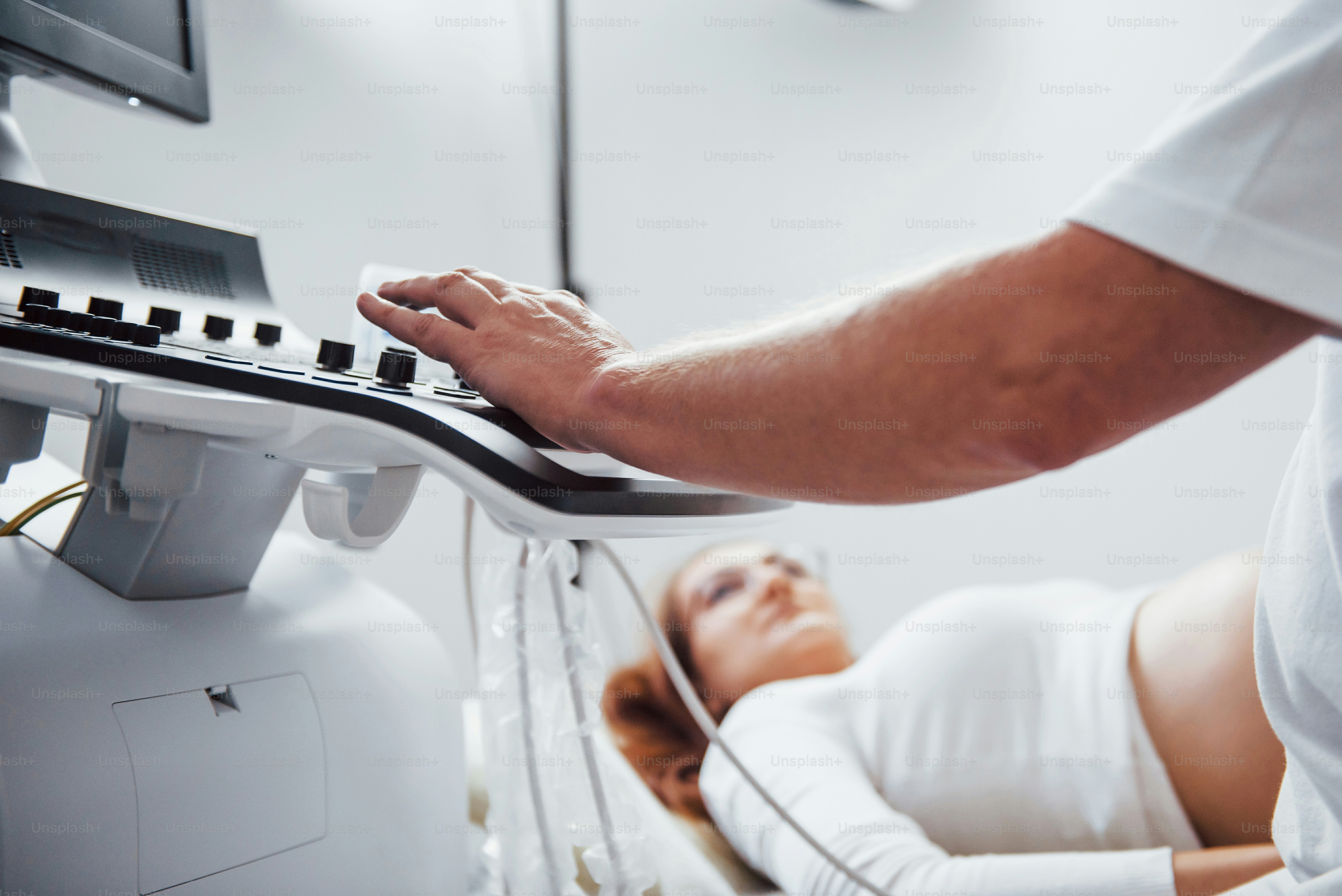 Male doctor does ultrasound for a pregnant woman in the hospital.