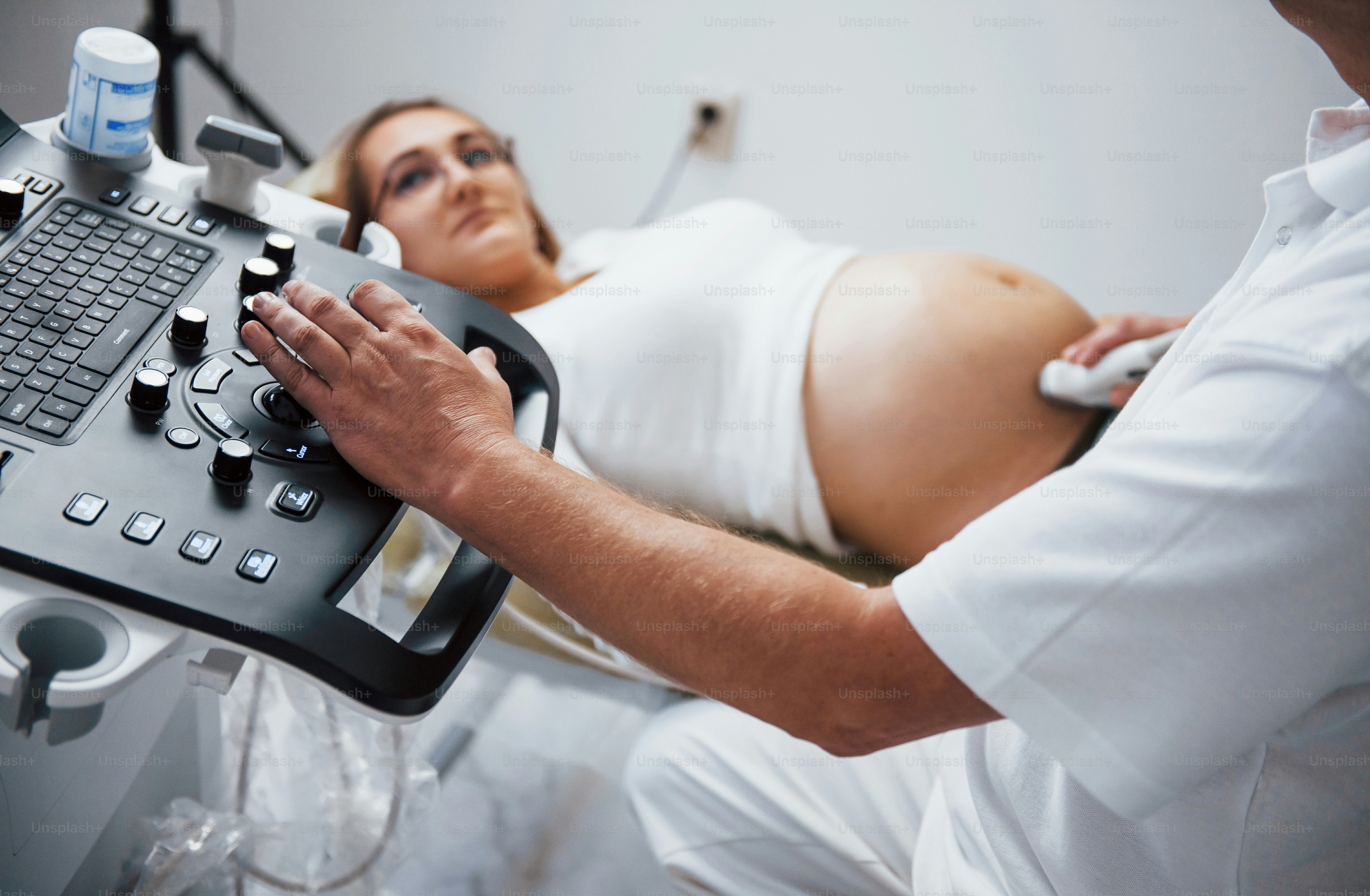 Male doctor does ultrasound for a pregnant woman in the hospital.