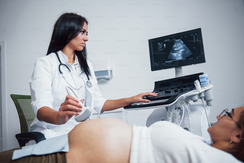 Una doctora hace una ecografía a una mujer embarazada en el hospital.