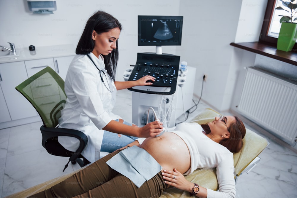 Female doctor does ultrasound for a pregnant woman in the hospital.