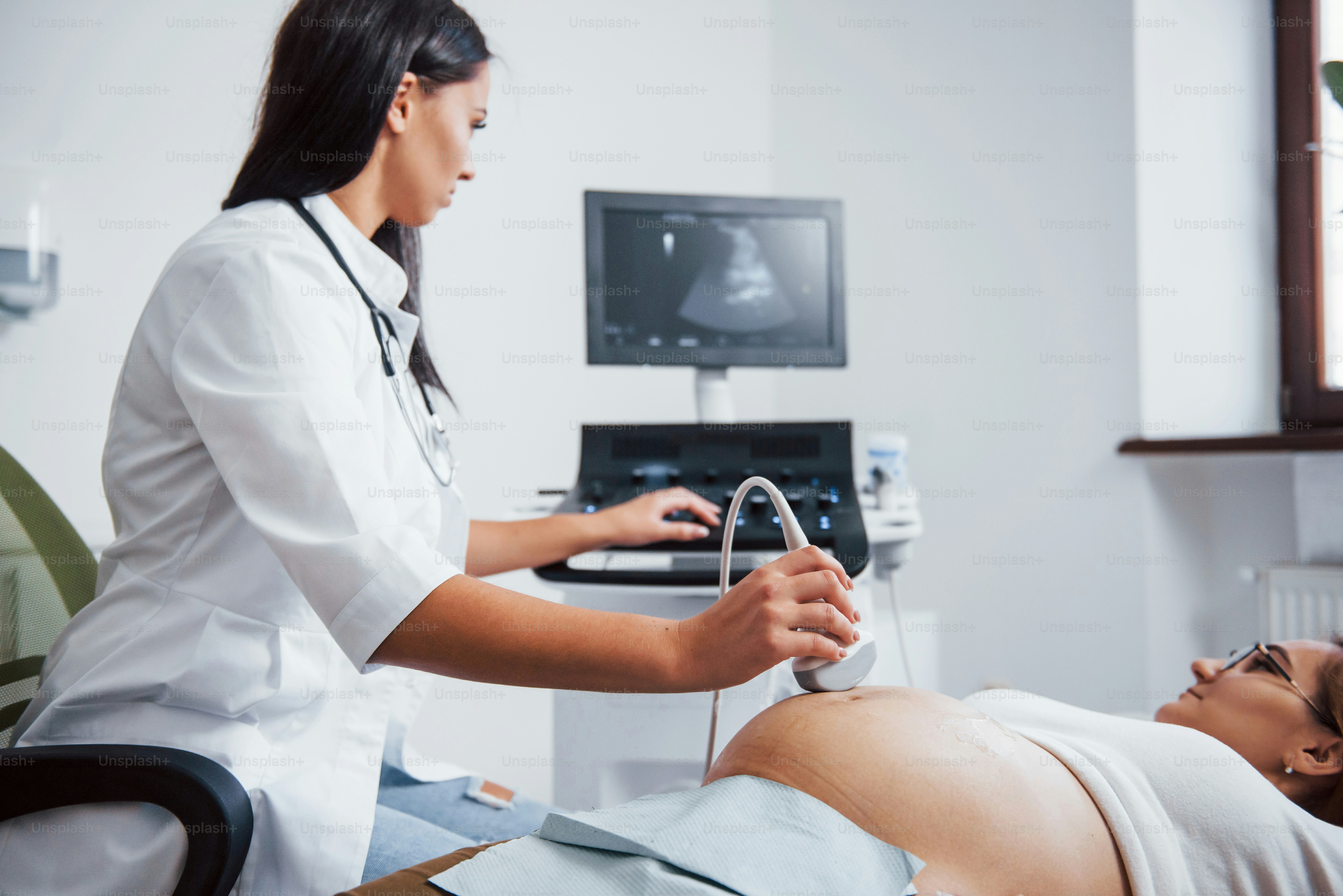 Female doctor does ultrasound for a pregnant woman in the hospital.