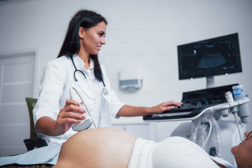 Une femme médecin fait une échographie pour une femme enceinte à l’hôpital.