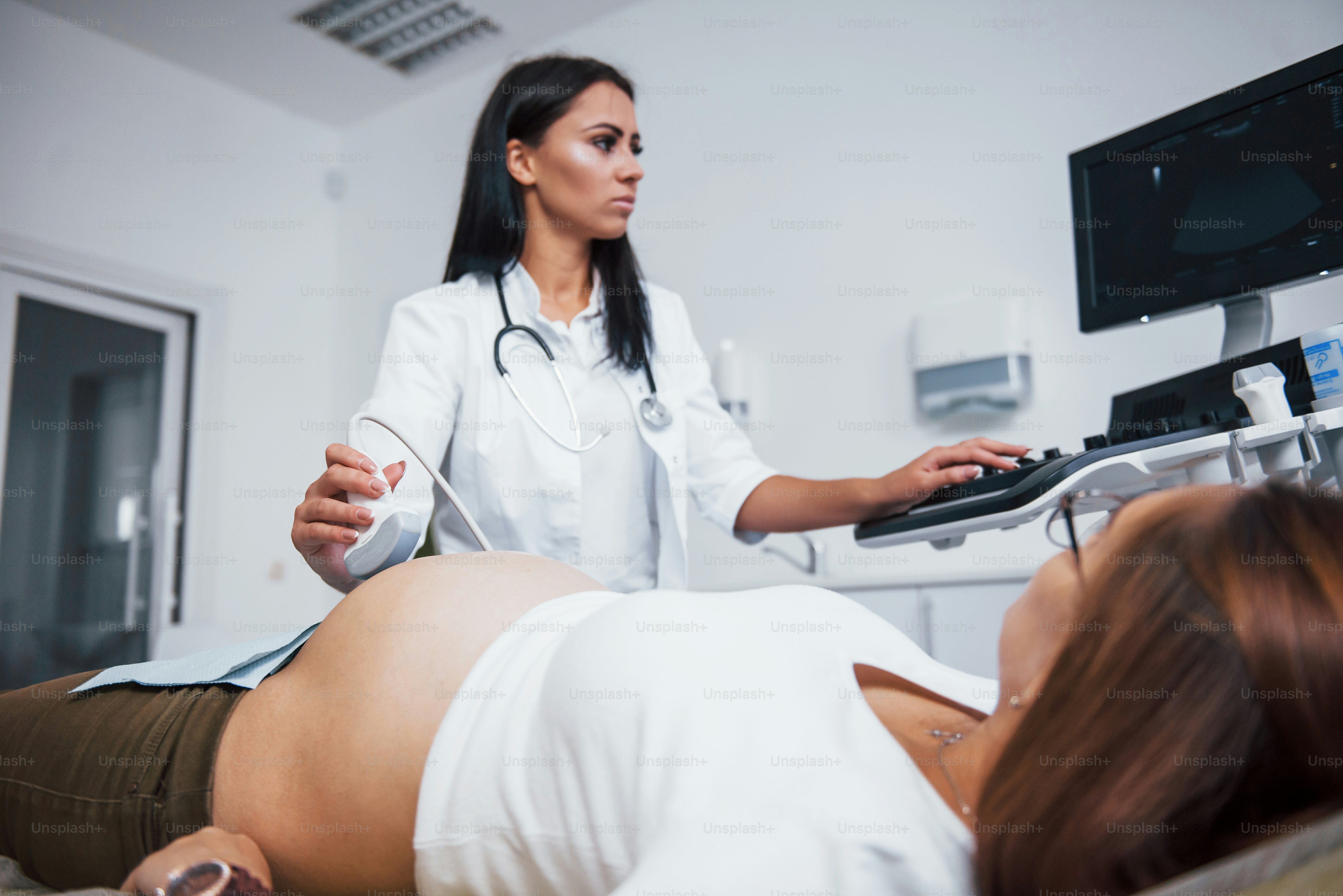 Female doctor does ultrasound for a pregnant woman in the hospital.