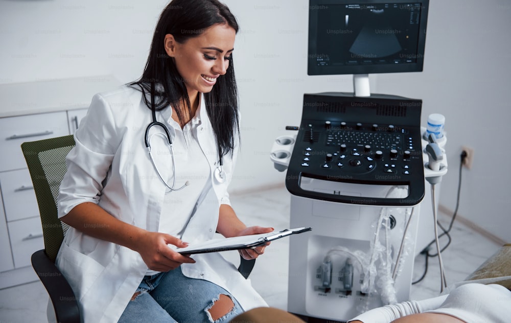 Portrait of obstetric doctor that sits in the clinic room with ultrasound device.