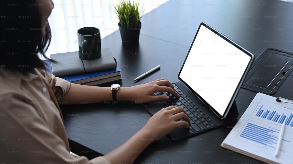 Cropped shot of young woman entrepreneur working with computer tablet and analyzing business performance.