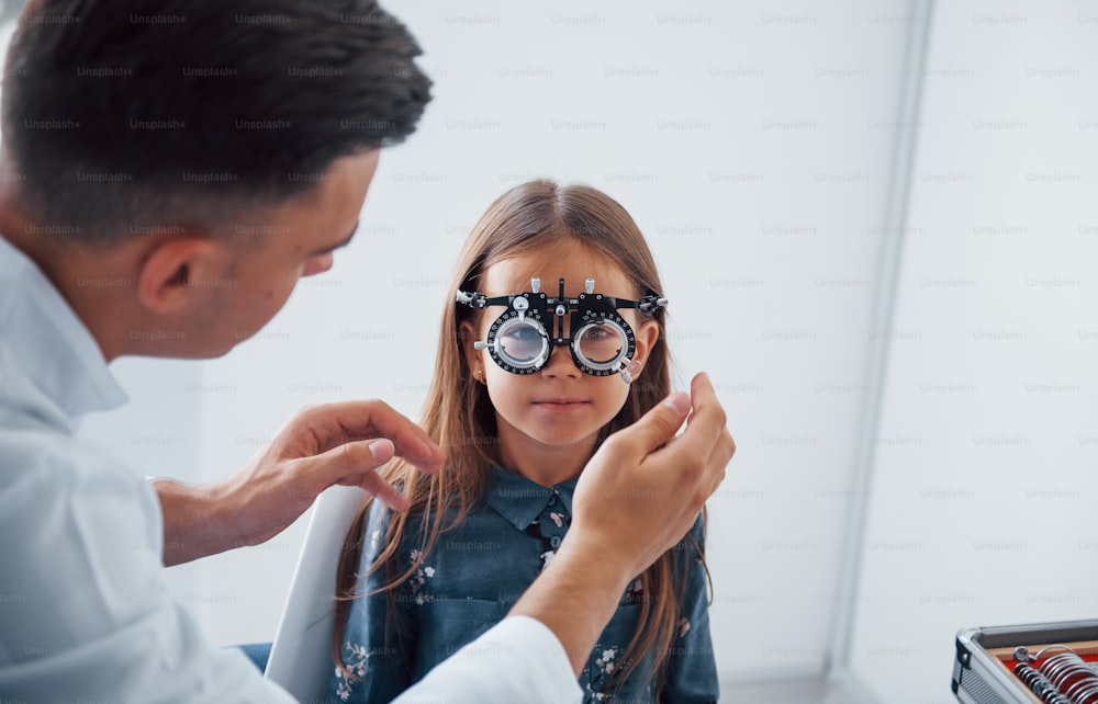 Tester la vision. Le jeune ophtalmologiste est avec peu de visiteurs féminins dans la clinique.