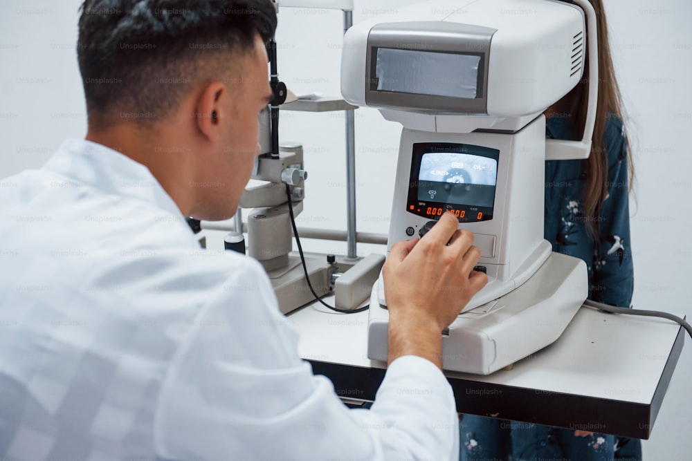 Oculist tests vision of patient by using special modern machine.