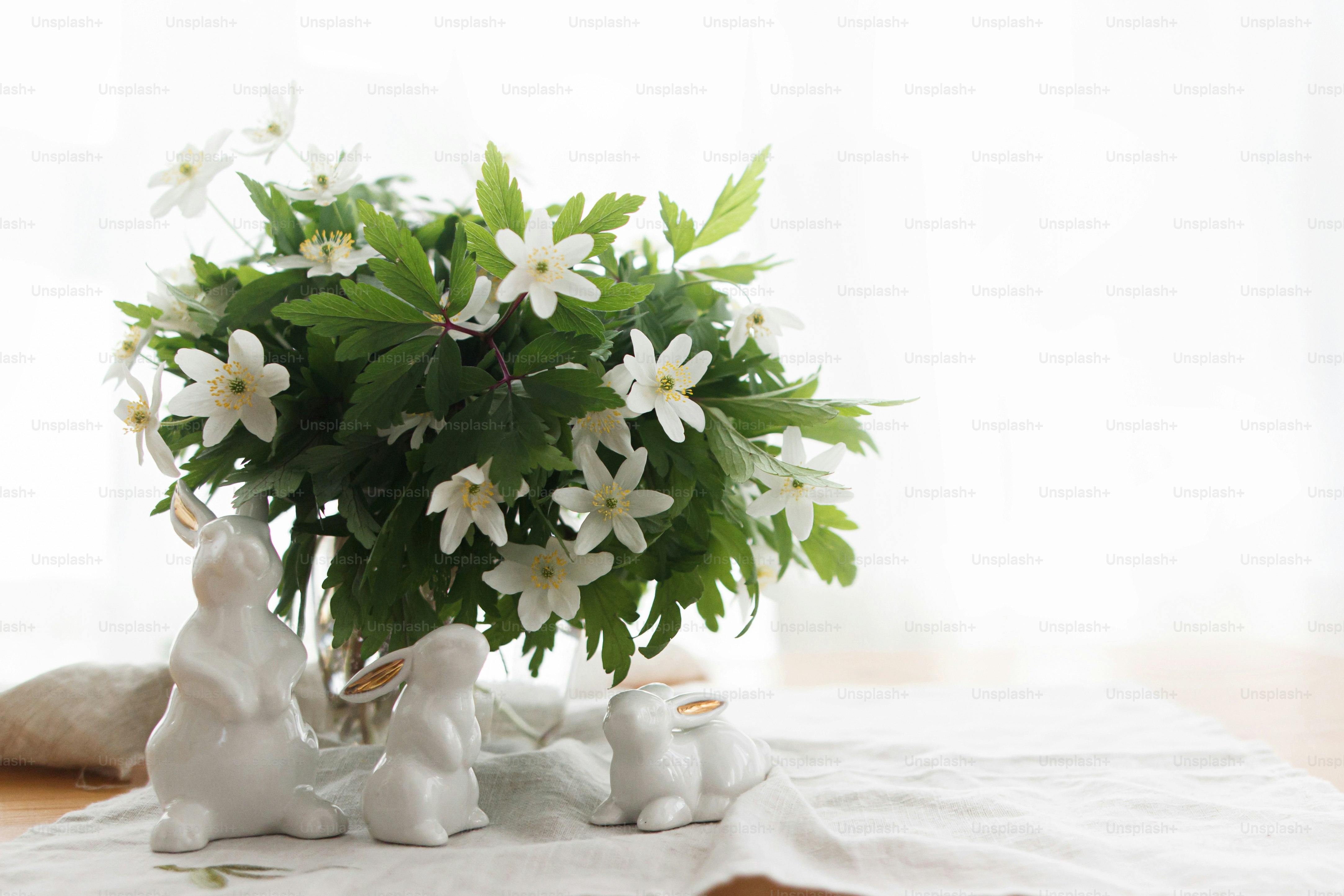 Happy Easter ! Cute white bunnies and spring flowers on linen cloth ...