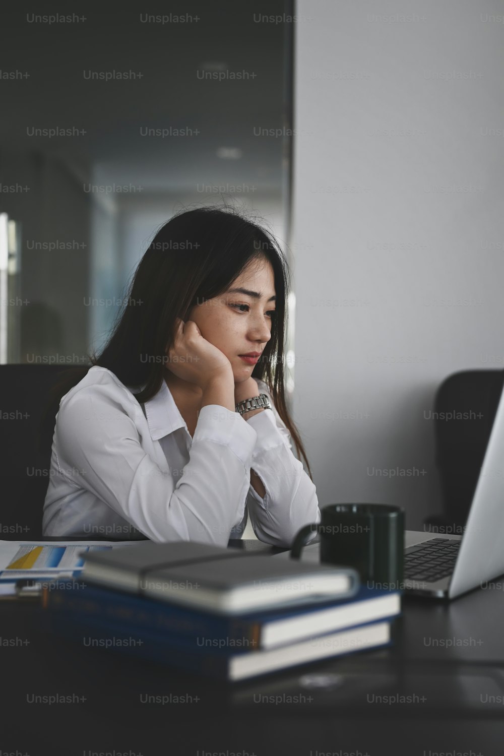 Portrait of focused young businesswoman looking at screen of computer laptop and feeling tired after unproductive work.