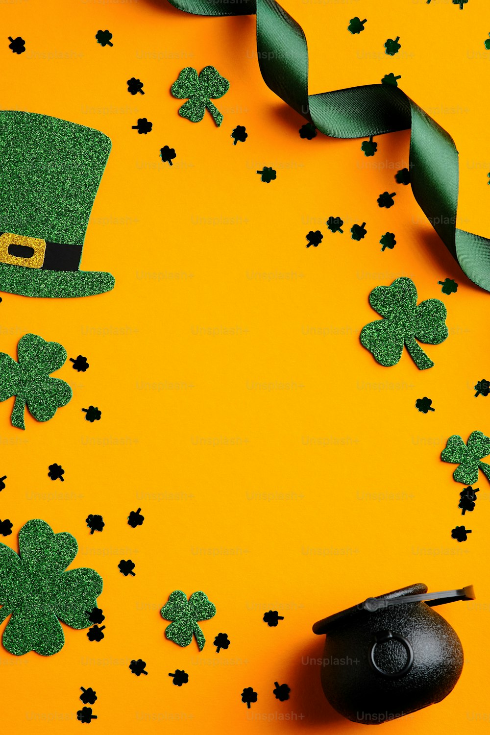 Saint Patrick's day card with green shamrock, leprechauns hat, pot of gold, ribbon and confetti on orange background. Happy St. Patrick's Day vertical banner design.