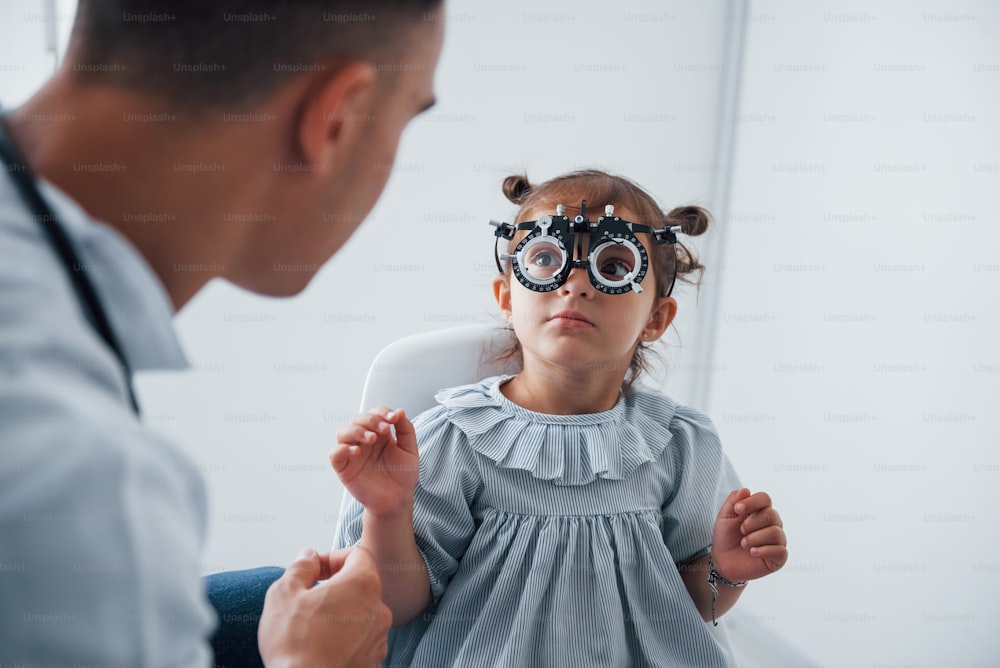 Testare la vista. Il giovane oftalmologo è con una piccola visitatrice nella clinica.