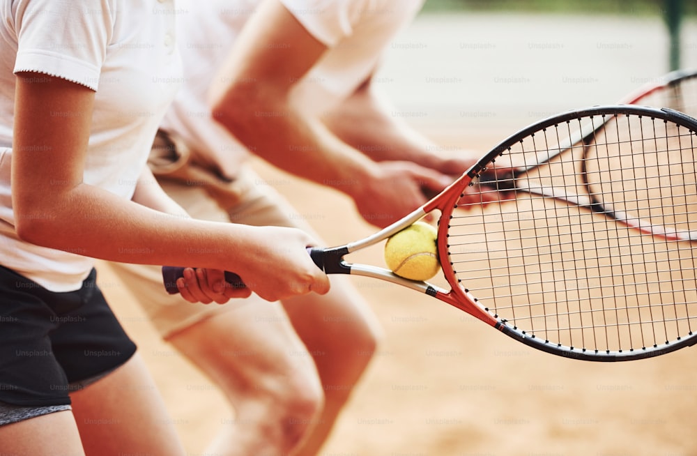 측면도. 야외 코트에서 여학생 테니스 경기를 가르치는 코치.