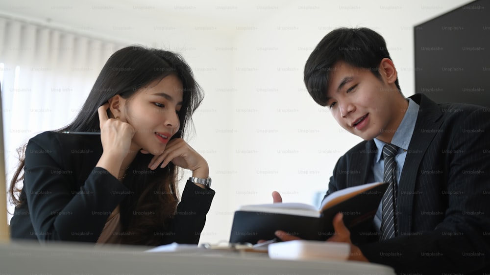 Businessman showing information to his colleague and discussing company financial strategy at office.