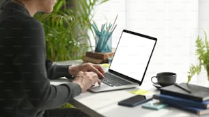 Young man freelancer sitting in comfortable workplace and using laptop computer.