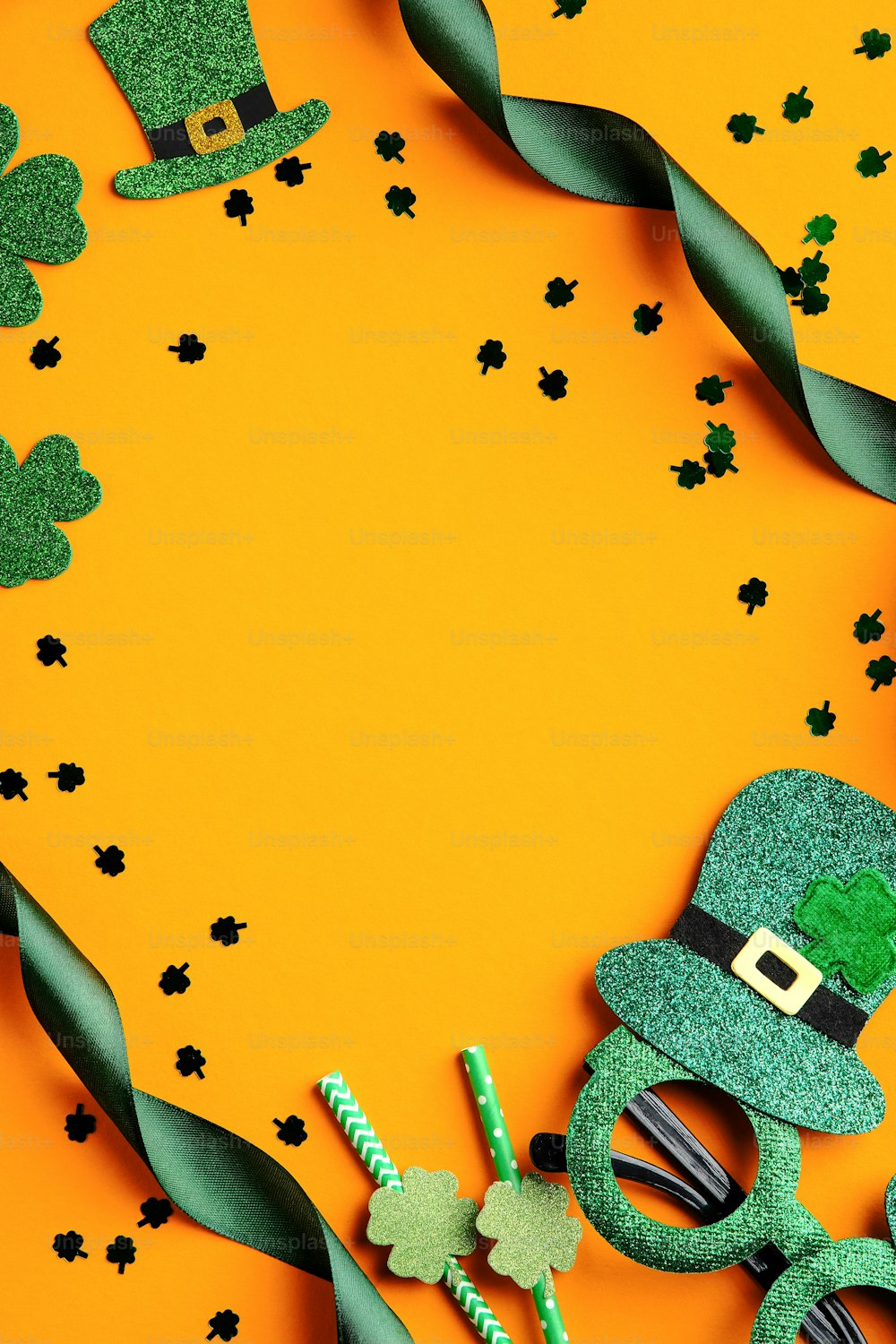 St Patrick's Day banner design. Irish elf hats, shamrock leaves, Patricks day glasses on orange background with copy space. Happy Saint Patricks Day concept
